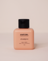 Pink square shampoo bottle labeled 'routine.' on a beige background